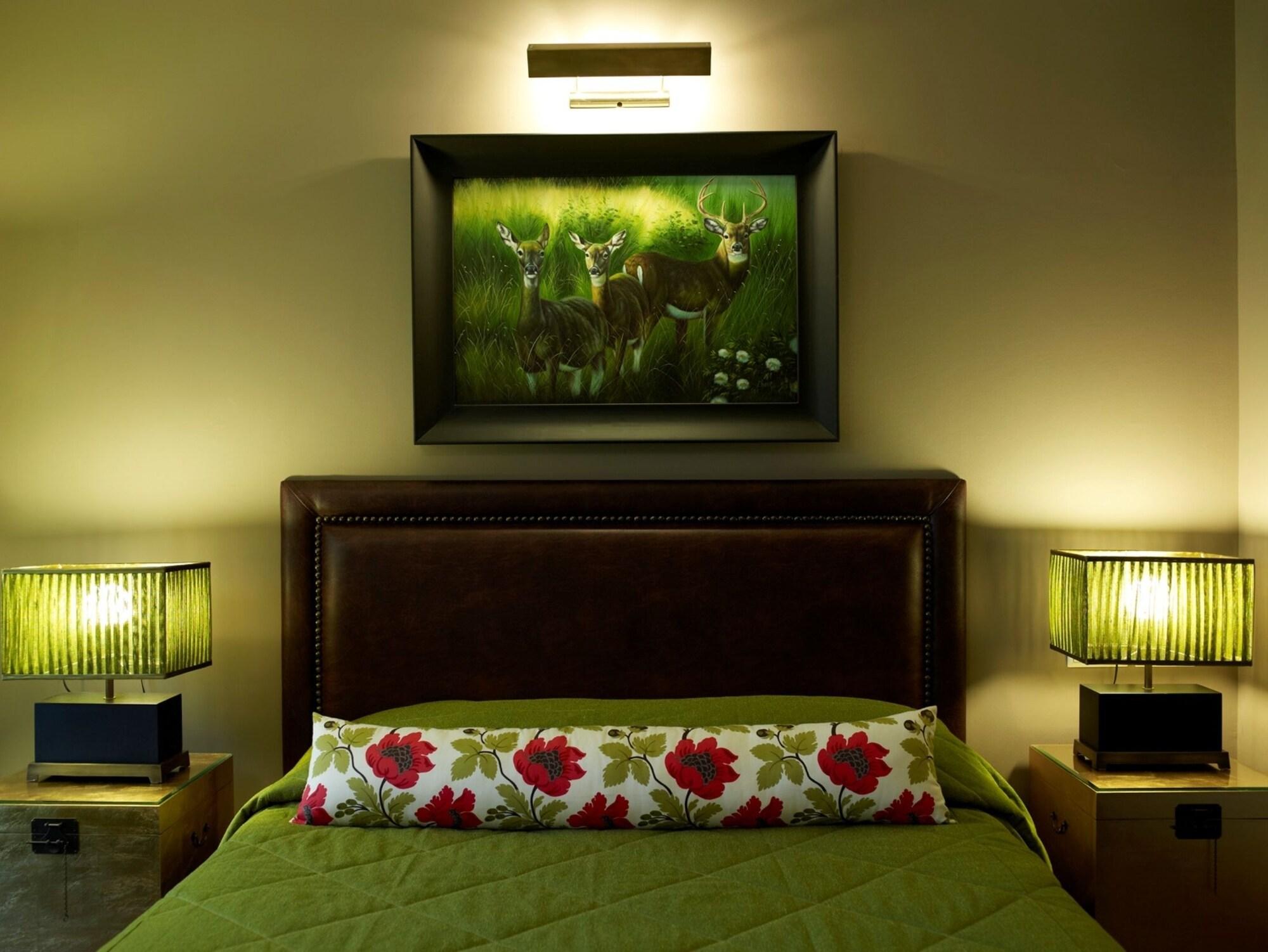 호텔 뒤 락 콩그레스 센터&스파 이오아니아 외부 사진 A bedroom with a bed, a painting, and two bedside lamps