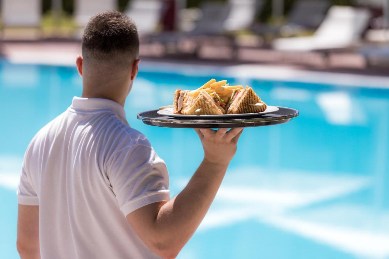 호텔 뒤 락 콩그레스 센터&스파 이오아니아 외부 사진 A waiter serving food